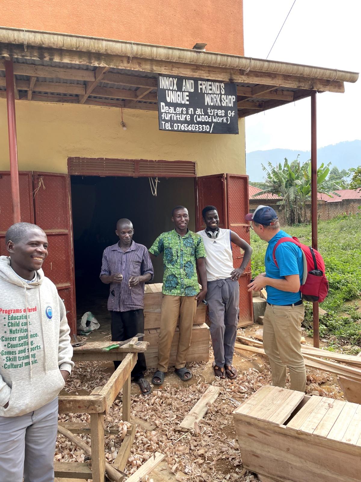 Woodworking workshop in Buhoma with four men standing in front of the business
