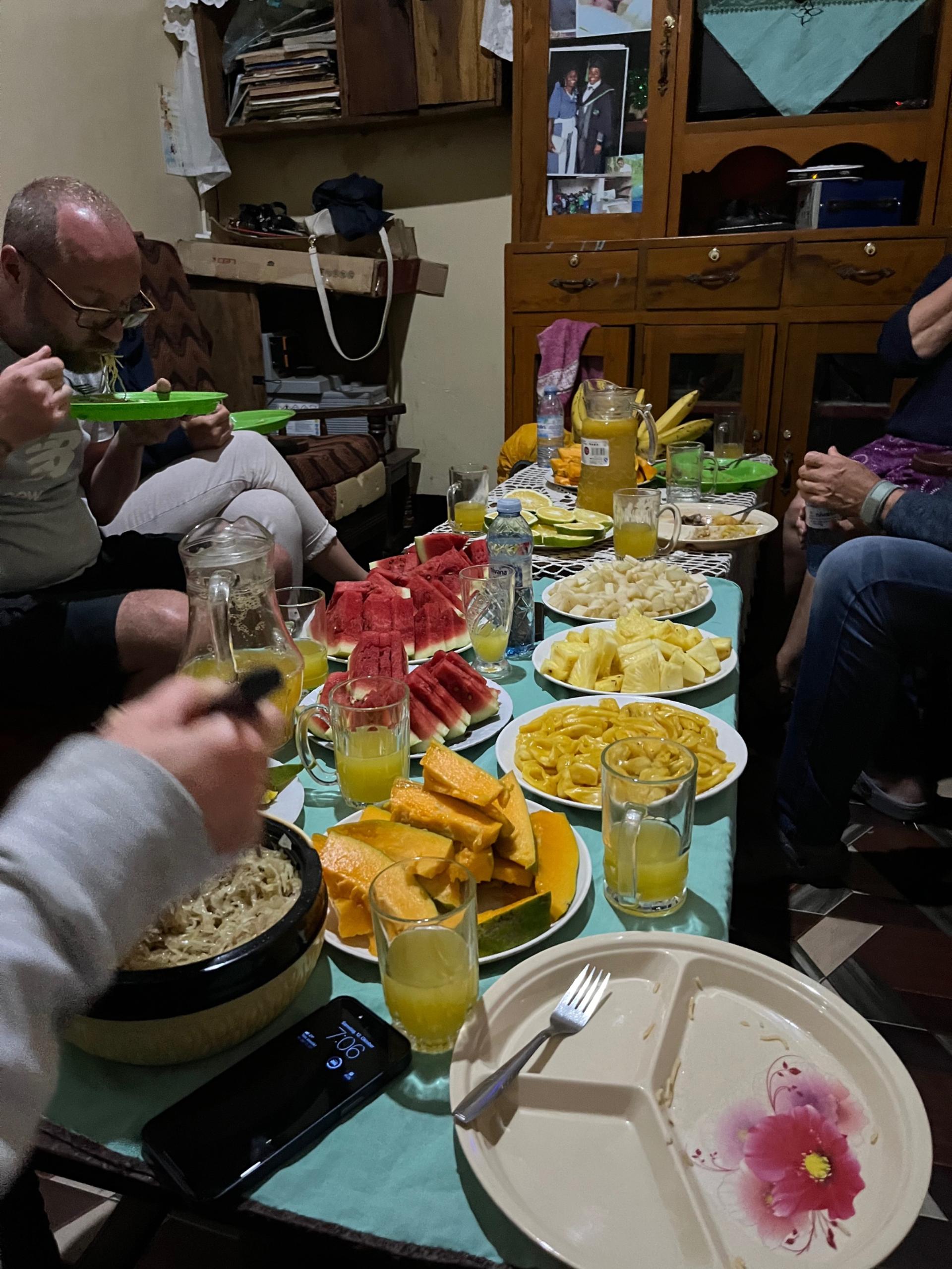 Traditional Ugandan meal in Butiru — fresh pineapple, avocado, chapati, and beans on plates