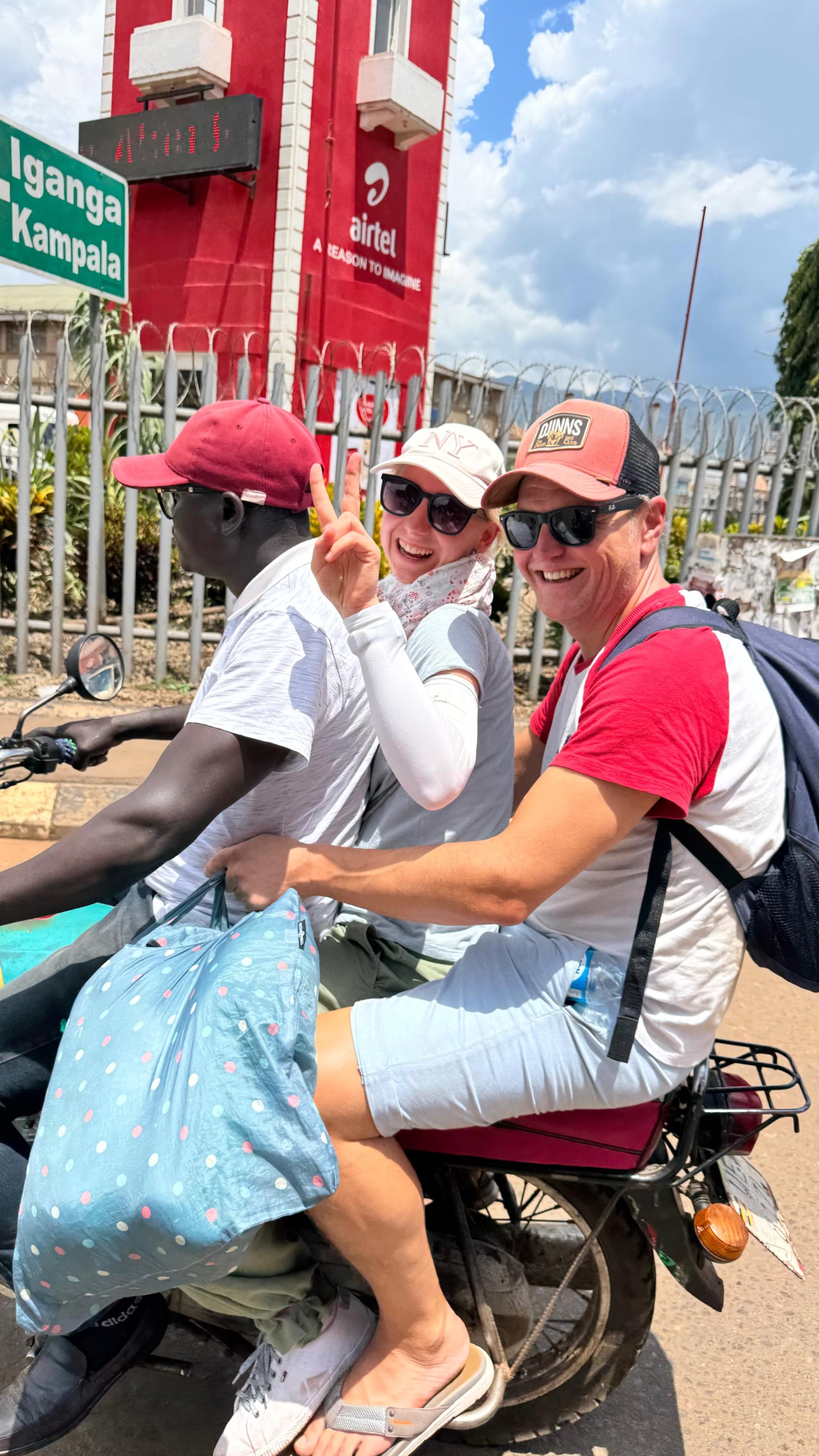 Three people sharing a boda-boda motorcycle taxi in Jinja, Uganda — a moment of everyday travel and cultural connection